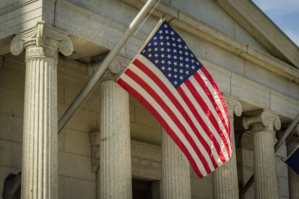An American flag in front of a court house.